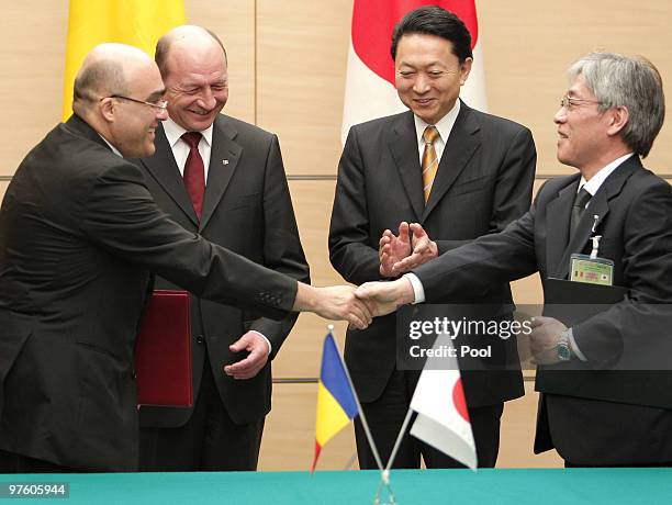 Romanian President Traian Basescu, second left, and Japanese Prime Minister Yukio Hatoyama, second right, look on as Romanian Ambassador to Japan...