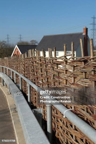 Willow fencing on a roadside acting as a protective barrier.