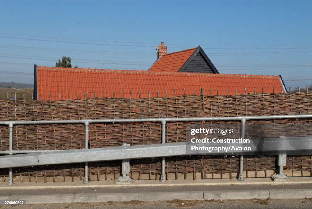 Willow fencing on a roadside acting as a protective barrier