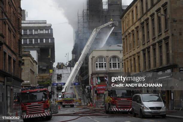 Firefighters work at the scene of a fire at the Glasgow school of art in Glasgow on June 16, 2018. Fire ripped through one of the world's top art...