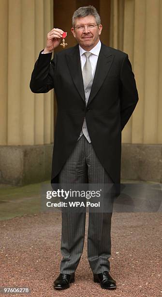 Mercedes F1 Team Principle Ross Brawn holds up his OBE, which was awarded to him by Queen Elizabeth II at Buckingham Palace, March 10, 2010 in London.