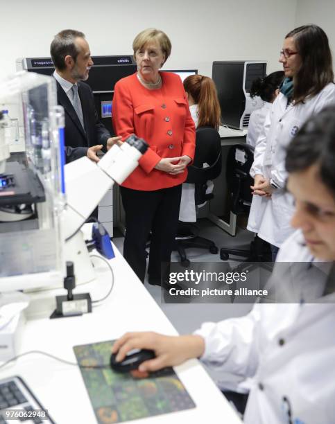 May 2018, Portugal, Lisbon: German Chancellor Angela Merkel and Director of the Institute for Health Research, Mario Barbosa, visiting the institute...