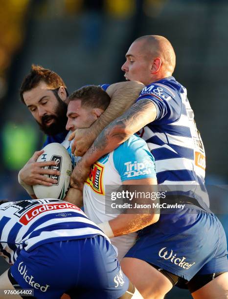 Brenko Lee of the Titans is tackled Aaron Woods and David Klemmer of the Bulldogs during the round 15 NRL match between the Canterbury Bulldogs and...