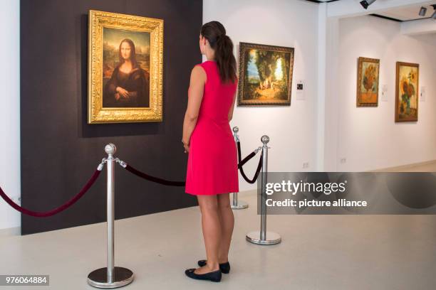 May 2018, Germany, Hamburg: A young woman standing in front of a copy produced by Eugen, Semjon and Michael Posen of the painting "Mona Lisa"...