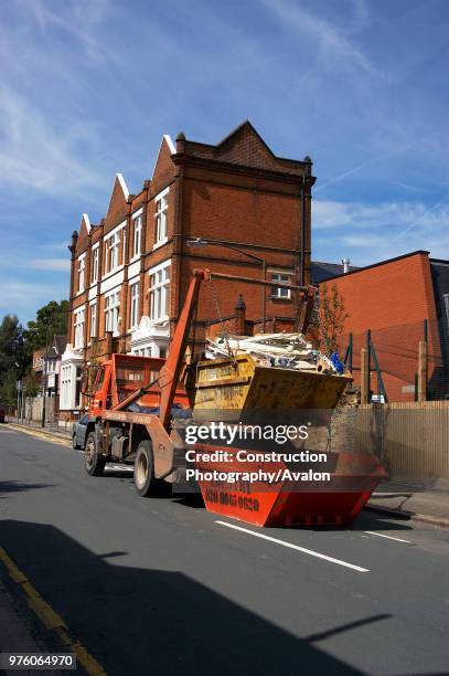 Skip loader truck collecting a skip.