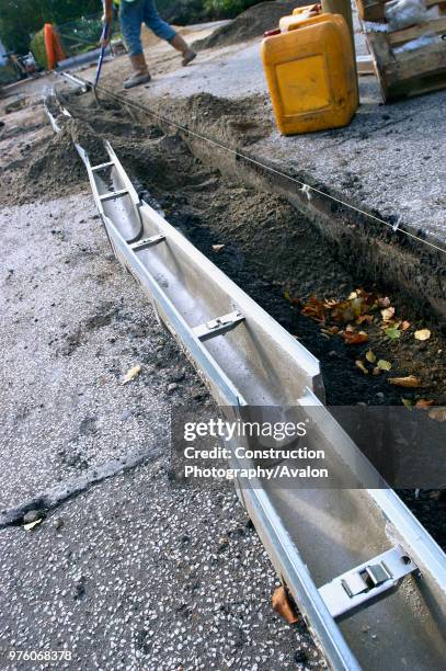 Footing drain pipes installed on pavement.