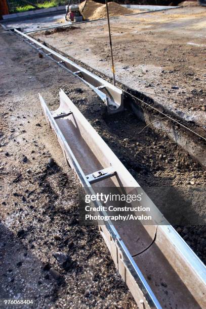 Footing drain pipes installed on pavement.