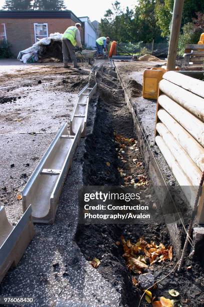 Footing drain pipes installed on pavement.