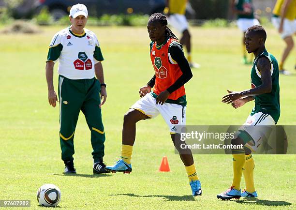 Head coach Carlos Alberto Parreira looks on as Reneilwe Letsholonyane and Teko Modise dispute the ball during the South Africa national soccer team...