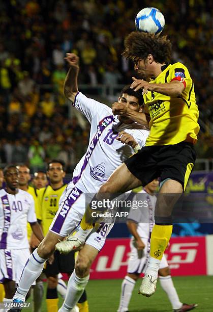 Hadi Aghily of Iran's Sepahan club jumps for the ball with Muhanad Salem of Emirati Al-Ain club during their AFC Champions League football match in...
