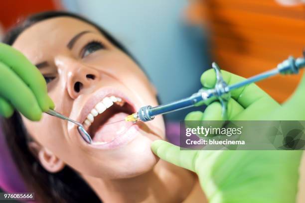 dentist holding a syringe and anesthetizing his patient - surgical suture stock pictures, royalty-free photos & images