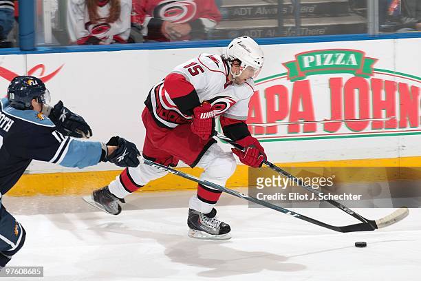 Tuomo Ruutu of the Carolina Hurricanes skates with the puck against David Booth 10 of the Florida Panthers at the BankAtlantic Center on March 6,...