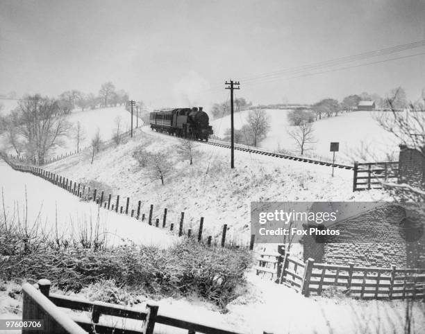 Train passes through a snowy landscape in Derbyshire, January 1936.