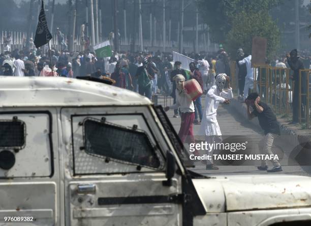 Kashmiri youths throw stones during clashes between protesters and Indian government forces in Srinagar on June 16, 2018. - Clashes broke out after...