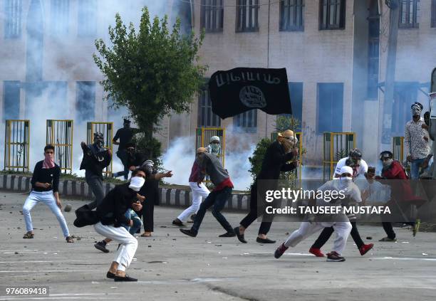 Kashmiri youth waves an Islamic State group flag during clashes between protesters and Indian government forces in Srinagar on June 16, 2018. -...