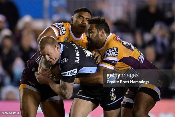 Luke Lewis of the Sharks is tackled during the round 15 NRL match between the Cronulla Sharks and the Brisbane Broncos at Southern Cross Group...