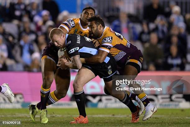 Luke Lewis of the Sharks is tackled during the round 15 NRL match between the Cronulla Sharks and the Brisbane Broncos at Southern Cross Group...