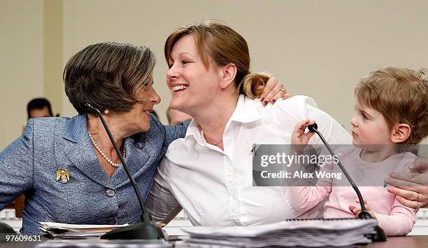 Desni Crock of Marietta, Ohio, is hugged by U.S. Rep. Jan Schakowsky as Crock's three-year-old daughter Bridget looks on after she told their stories...