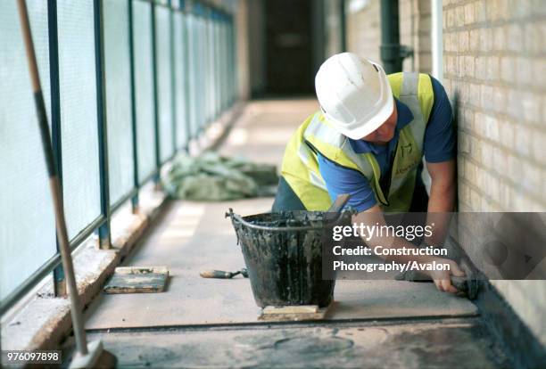 Asphalting Forming detail kerb, skirting Person attending asphalt pot.