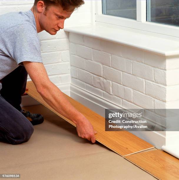 Man laying new laminated floorboard.