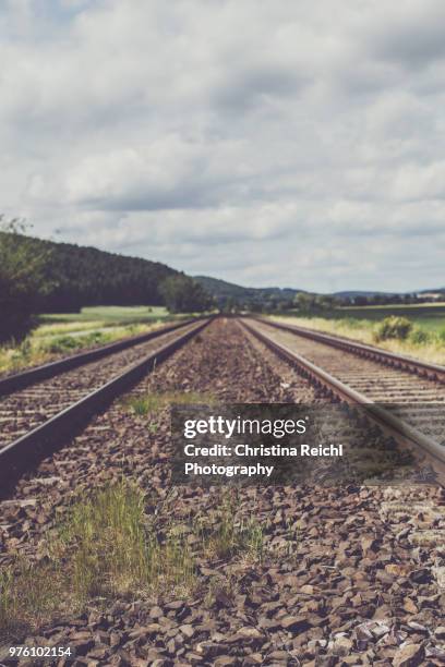 train tracks in beautiful landscape leading to somewhere in the distance - christina langer stock-fotos und bilder