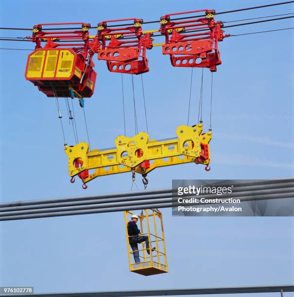 Cable hauler carrying man during construction of the Millennium Bridge, London, UK.
