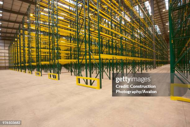 Empty warehouse with shelving and racks.