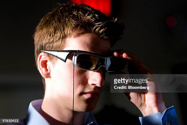 An attendee wears 3-D active shutter glasses in front of a new Panasonic Corp. Viera full HD 3-D 50 inch television during a launch event at a Best...