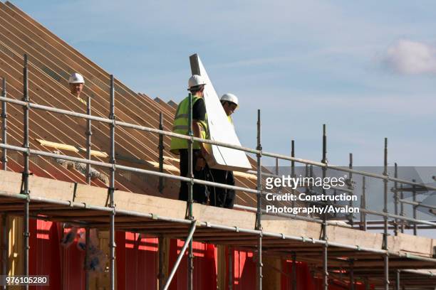 Construction workers carrying pre-fabricated section at new housing development, Cambridge, England, UK.