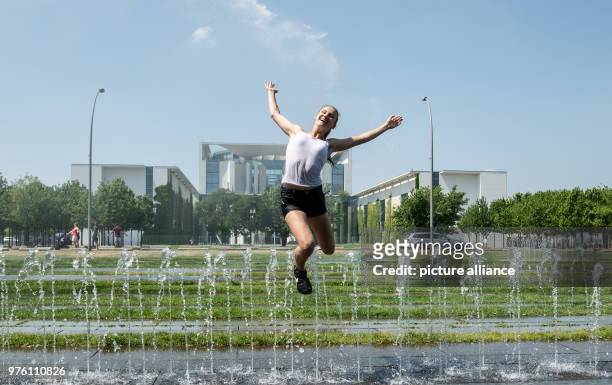 May 2018, Berlin, Germany: Johanna from Frankfurt am Main jumps over the water fountains in front of the Federal Chancellery Photo: Paul Zinken/dpa