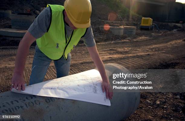 Building technician checking plan on site.