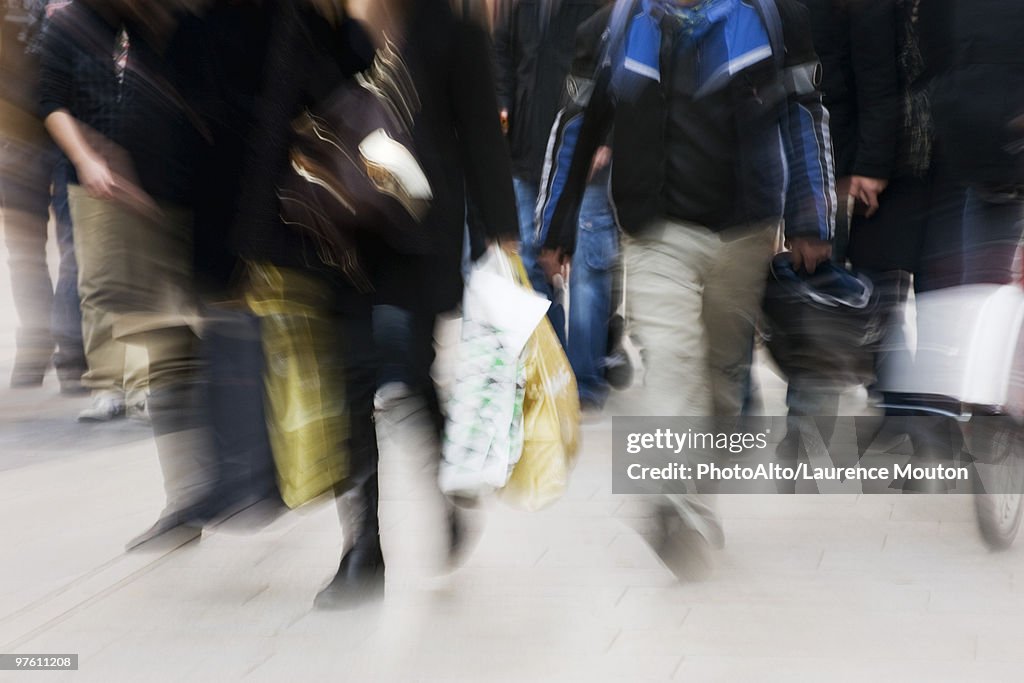 Pedestrians walking on sidewalk, blurred