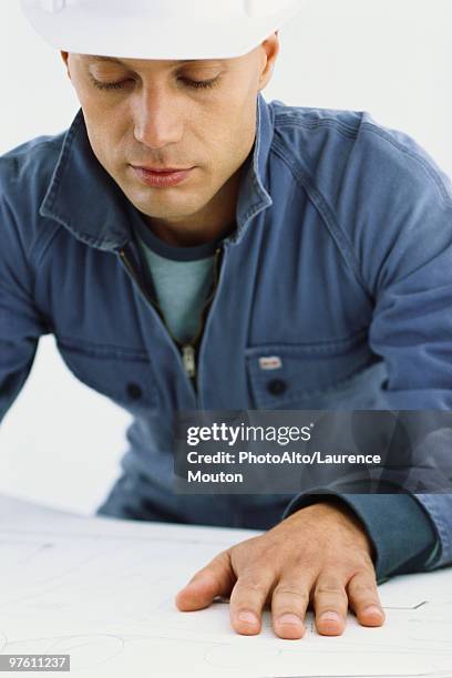 handyman looking at blueprints - handyman overalls stock pictures, royalty-free photos & images