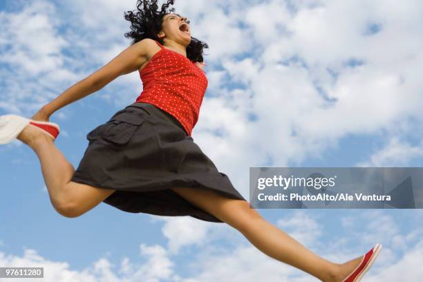 young woman jumping in midair, low angle view - red ale stock pictures, royalty-free photos & images