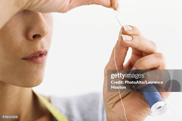 woman threading needle, cropped - threading stock pictures, royalty-free photos & images