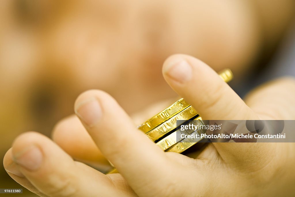 Child's hand holding chocolate candy coins