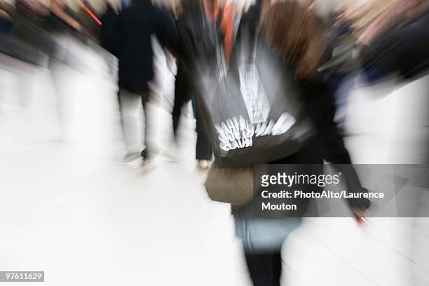 shopper carrying shopping bag, blurred - mitziehen stock-fotos und bilder