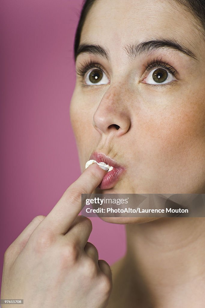 Woman licking ice cream from finger