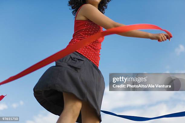 young woman spinning around with ribbons outdoors - skirt blowing stock pictures, royalty-free photos & images