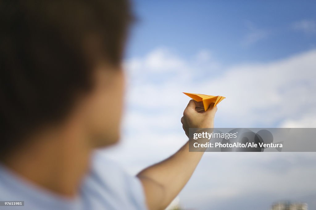 Man throwing paper airplane