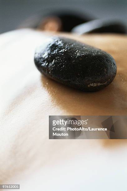 lastone therapy, stone placed on patient's bare back - bare back stock-fotos und bilder