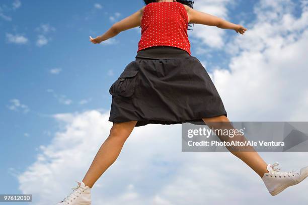 young woman jumping in midair, cropped - skirt stock pictures, royalty-free photos & images