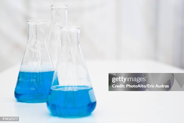 beakers containing blue liquid - conical flask stock pictures, royalty-free photos & images
