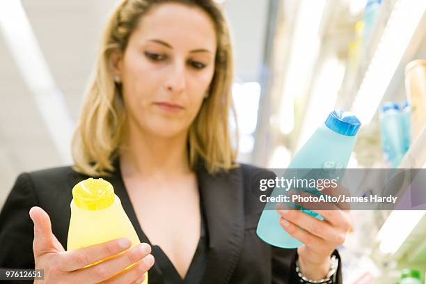 woman comparing body care products - holding two things stock pictures, royalty-free photos & images