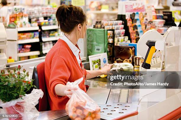 cashier totaling grocery purchases - ladenkasse stock-fotos und bilder