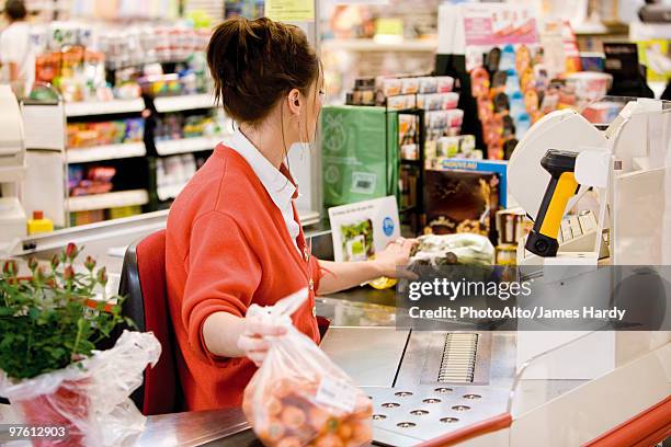 cashier totaling grocery purchases - kassa stockfoto's en -beelden