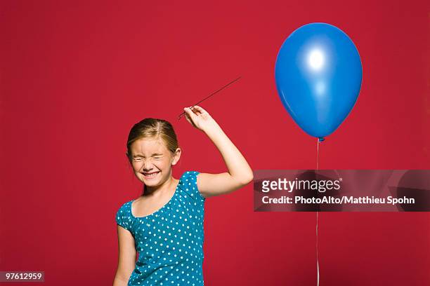 girl preparing to pop balloon - pin up girl stockfoto's en -beelden
