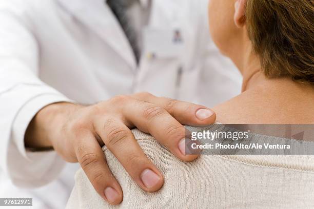 doctor's hand on patient's shoulder - hand on shoulder stock pictures, royalty-free photos & images