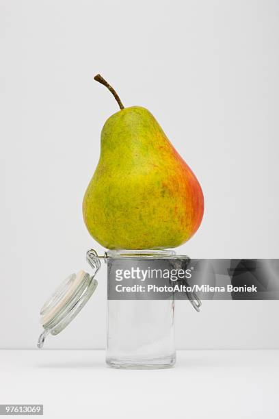food concept, pear on top of small glass jar - baggy green stock pictures, royalty-free photos & images