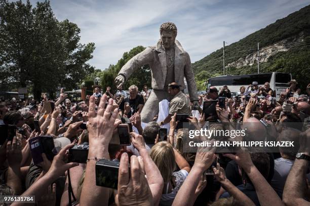 Fans take pictures as they attend the inauguration of a statue of late French rocker Johnny Hallyday by French sculptor Daniel Georges and set up in...